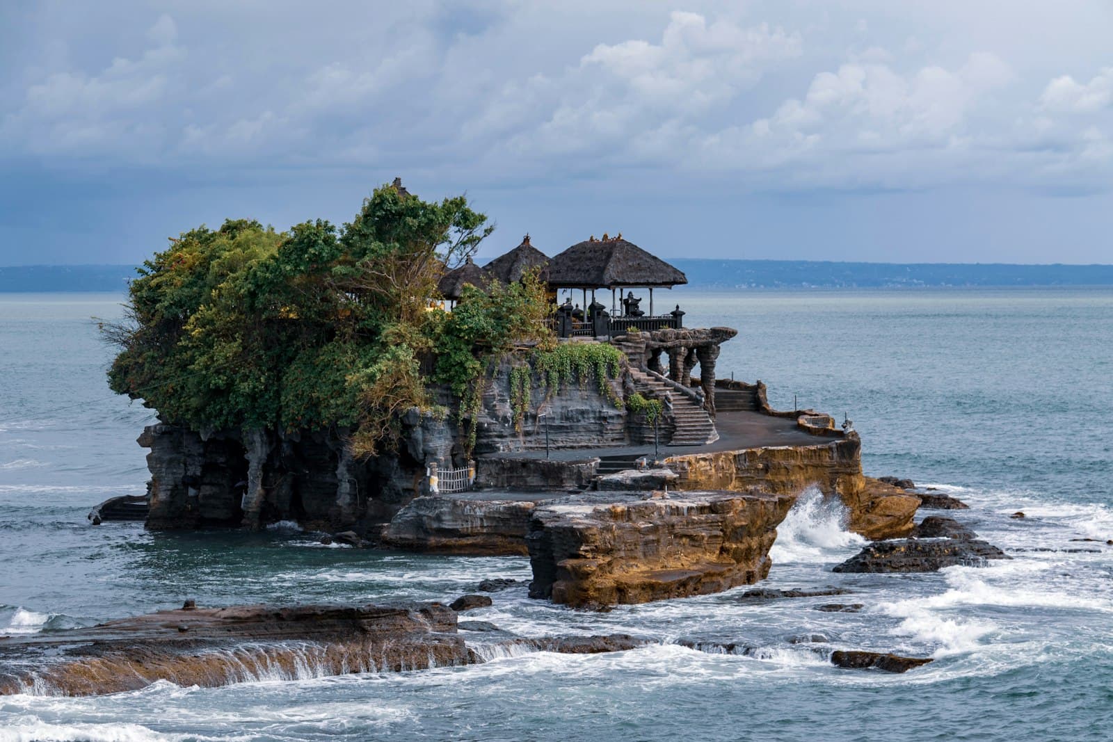 Pura Tanah Lot sea temple silhouetted against the sunset on a rocky outcrop off Bali’s west coast