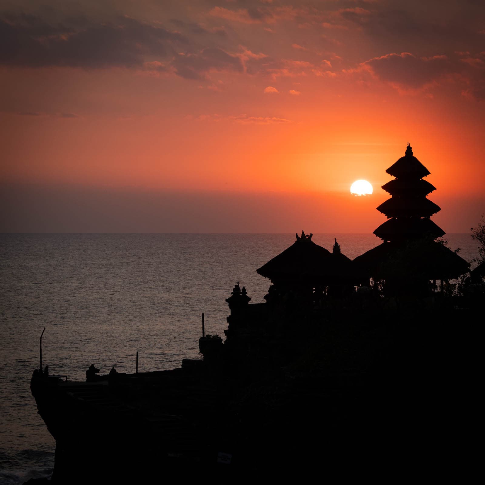 Pura Tanah Lot silhouetted against the sunset at low tide